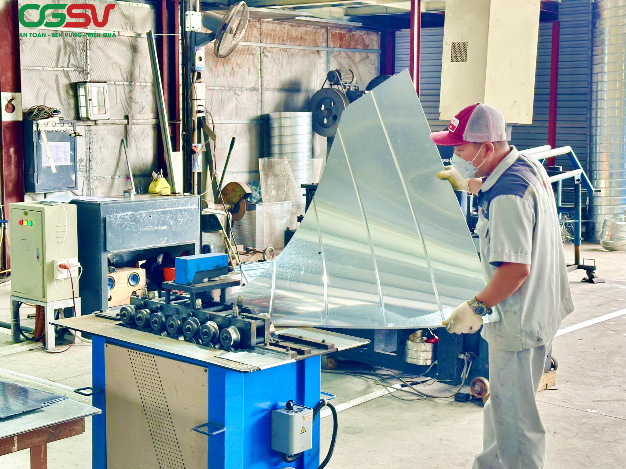 Công nhân gia công tấm tôn để sản xuất ống gió trong dây chuyền sản xuất tại nhà máy Ống gió Sao Việt