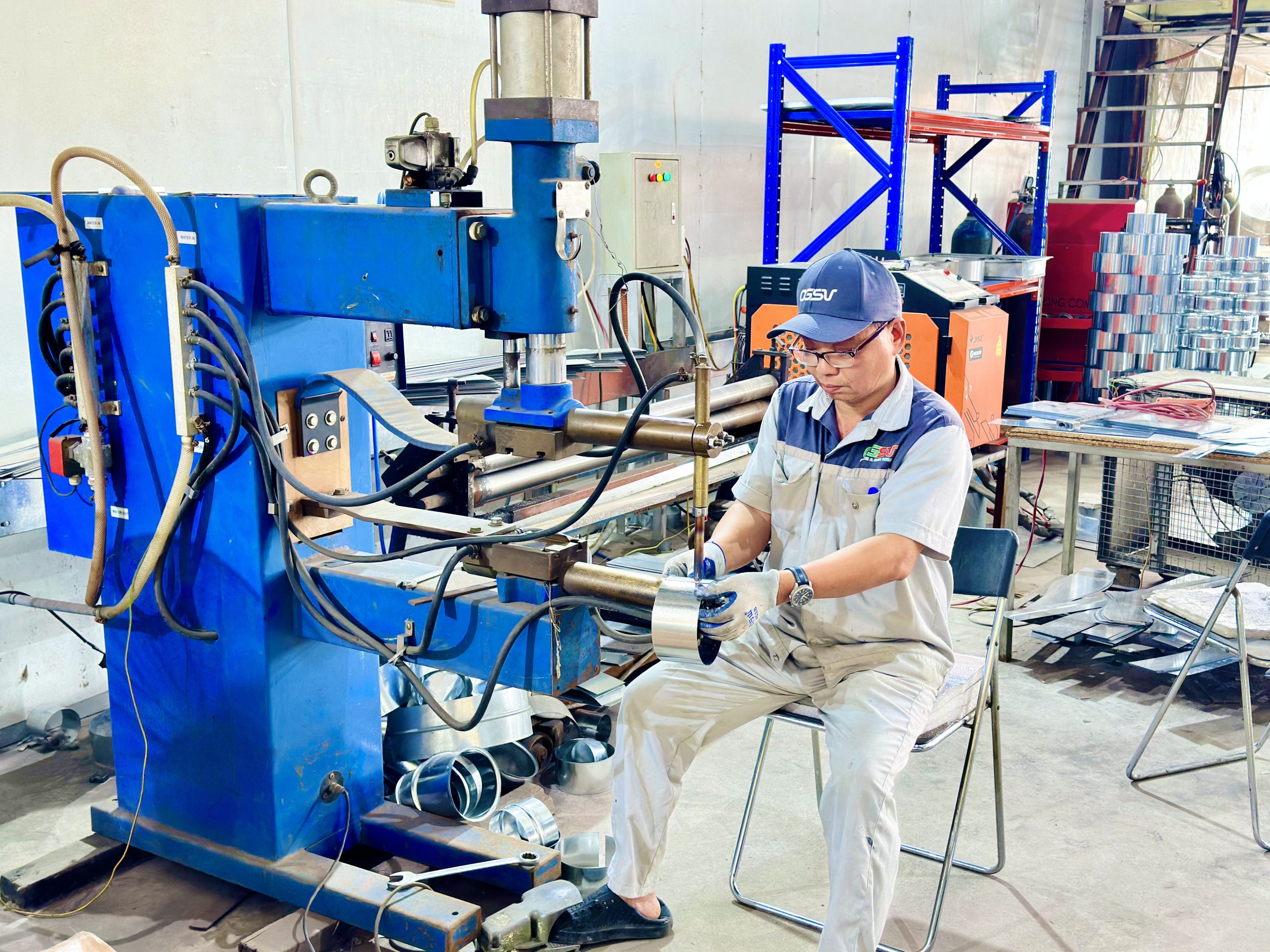 Công nhân vận hành máy gia công trong dây chuyền sản xuất ống gió tại nhà máy Ống gió Sao Việt